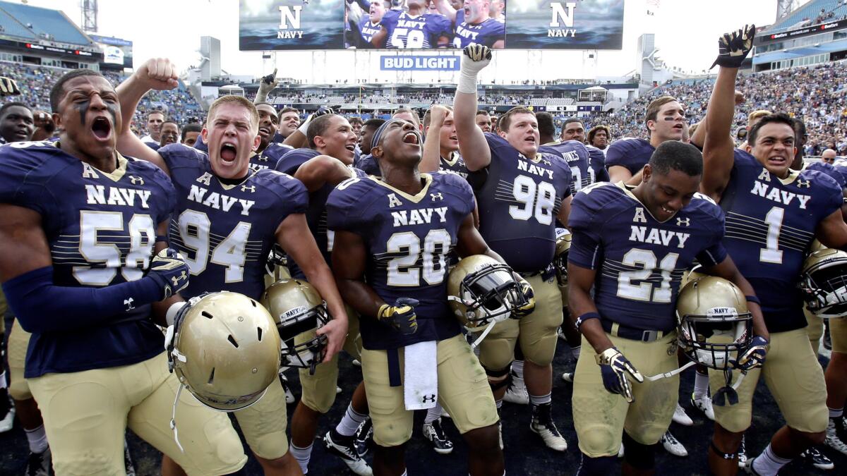 Navy players celebrate after defeating Notre Dame, 28-27, on Saturday.