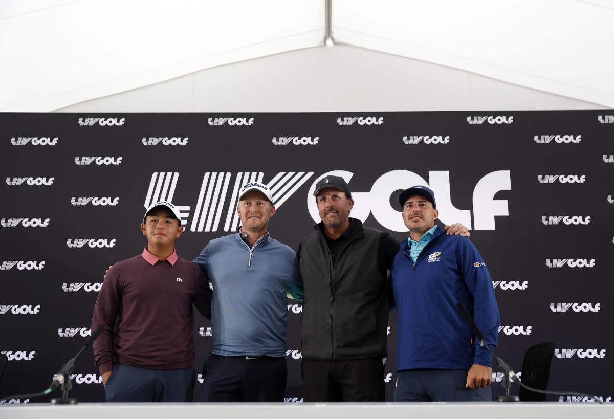 Four men stand in front of a backdrop printed with the LIV Golf logo