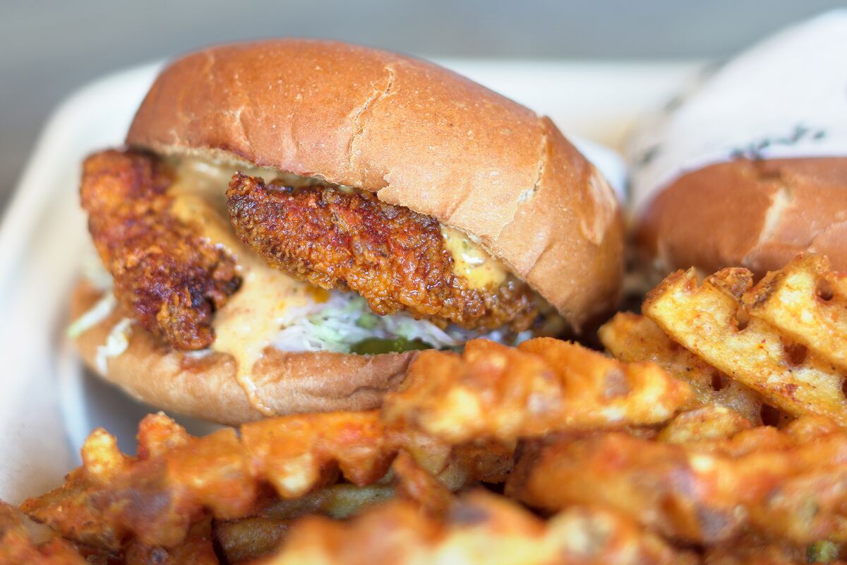 A fried chicken sandwich with french fries.