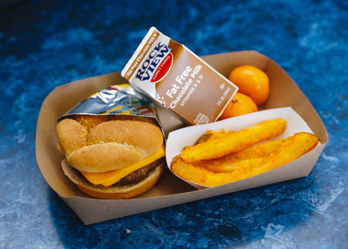 A cheeseburger with sides of oranges and fries with chocolate milk are offered for lunch at Garfield High School in 2022.