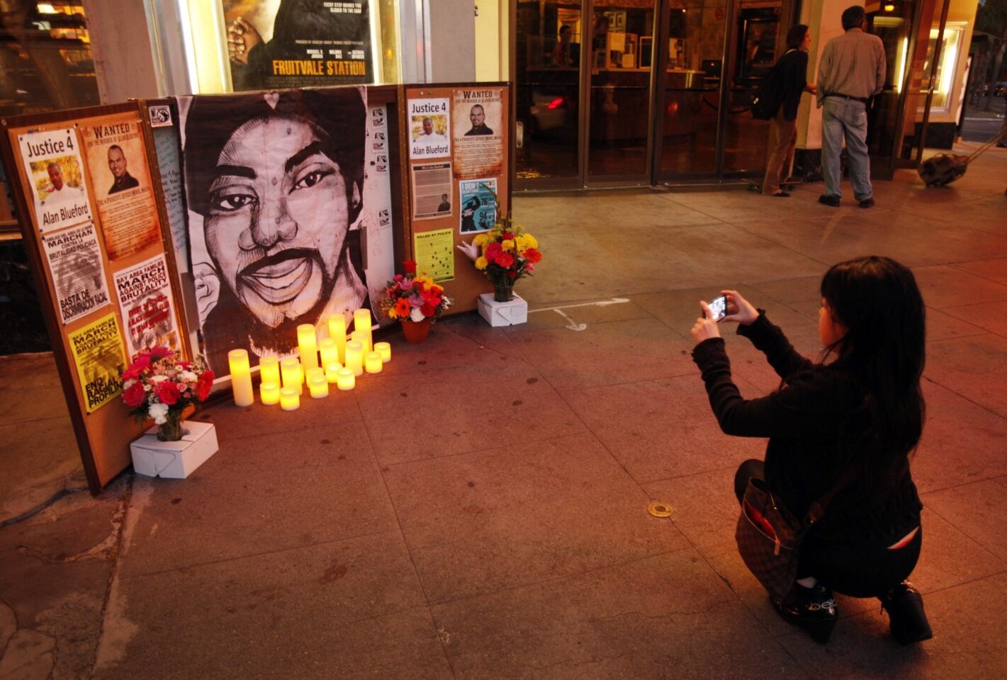 Malia Nguon takes a photo of a memorial to Oscar Grant at the Grand Lake Theatre on the night of the "Fruitvale Station" premiere.
