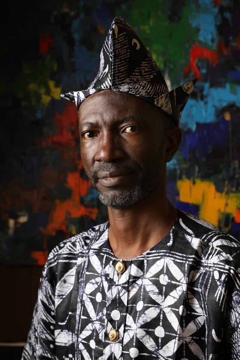 Artist Porter Ajayi, of Nigeria is exhibiting his work at the Pan African Film Festival's ArtFest at the Baldwin Hills-Crenshaw Plaza, Los Angeles on Feb. 12, 2023. (Carolyn Cole / Los Angeles Times)