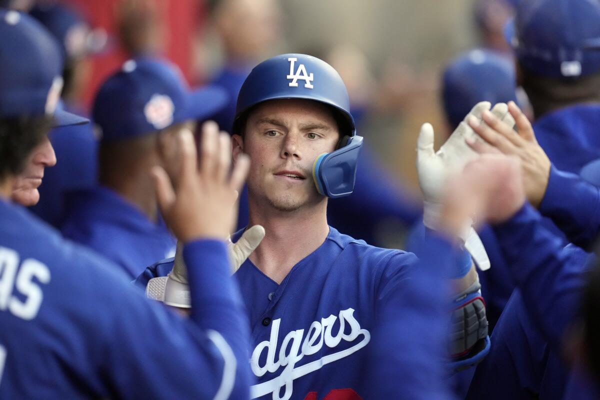 Los Angeles Dodgers' Will Smith is high-fived in the dugout after driving in a run with a sacrifice fly.