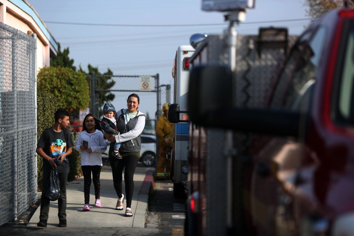 A parent and children leave Park Avenue Elementary School