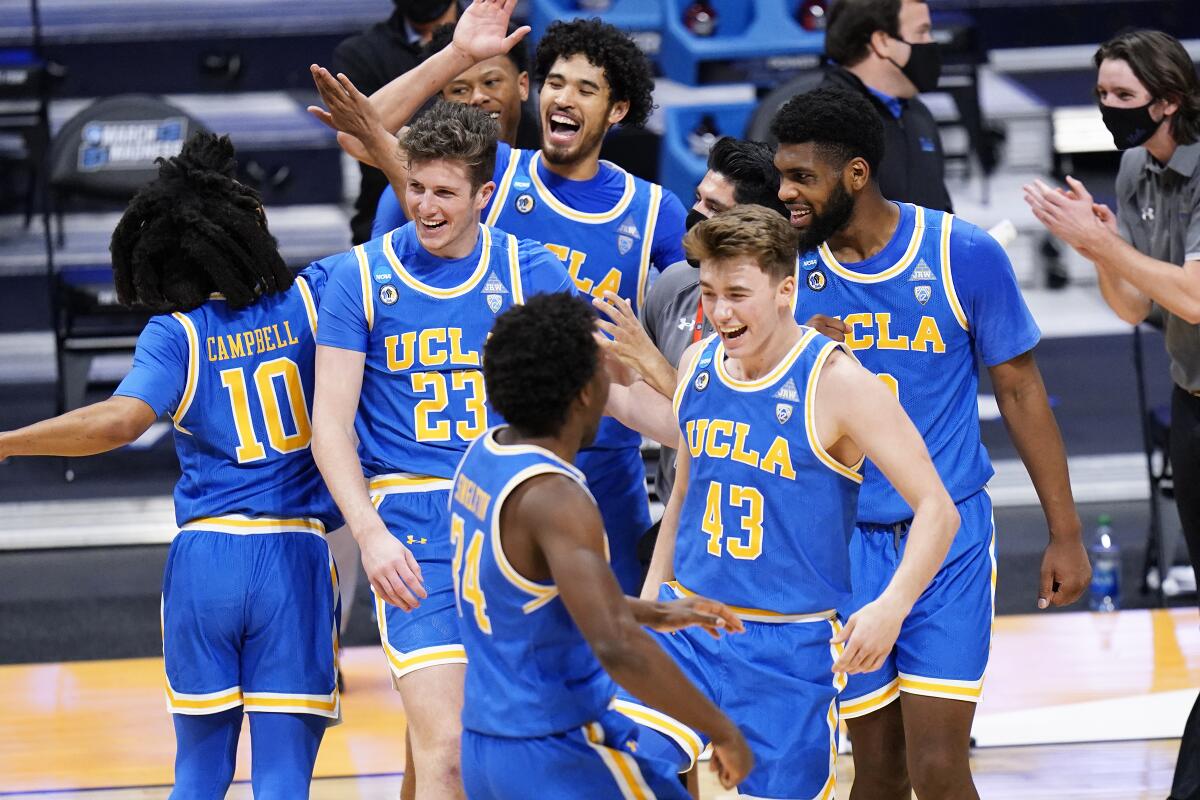 UCLA players high-five after their 73-62 victory over Brigham Young