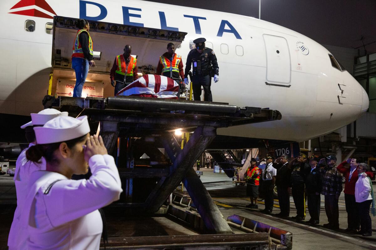 U.S. Navy sailors salute Raul Guerra's casket as it arrives at Los Angeles International Airport on April 23.