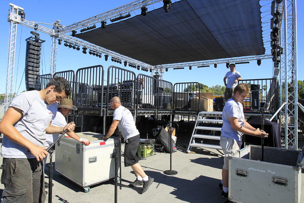 Workers prepare the main stage for the City of Costa Mesa's 60th anniversary bash on Wednesday.