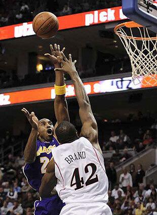 Lakers Kobe Bryant launches a jump shot as 76ers forward Elton Brand defends in the first half Wednesday.