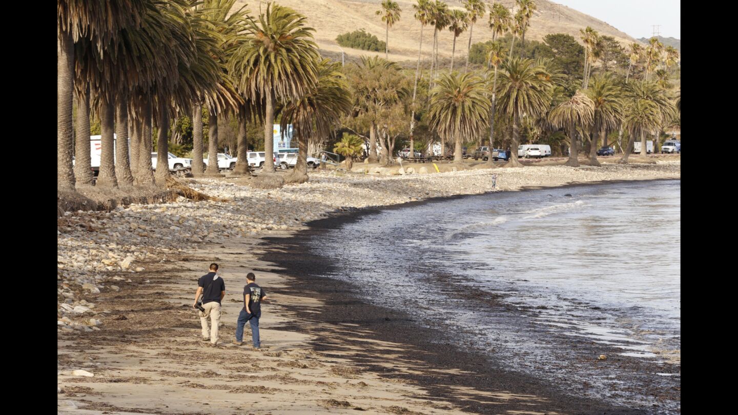 Diego Topete, left, and Ryan Cullom at Refugio State Beach. The oil spill left a 4-mile-long sheen extending about 50 yards into the water.