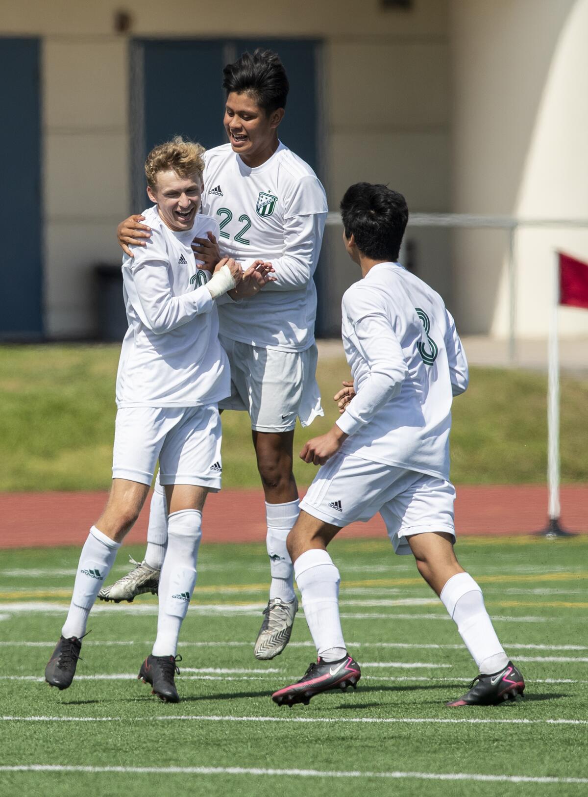 Edison's Kevin Blanco, right, and Ozzy Moran congratulate Trent Bellinger after he scored a goal against Fountain Valley.