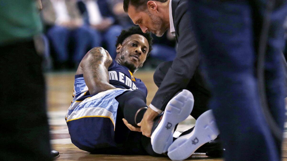 Grizzlies guard Mario Chalmers has his right leg examined after tearing his Achilles' tendon Wednesday night.