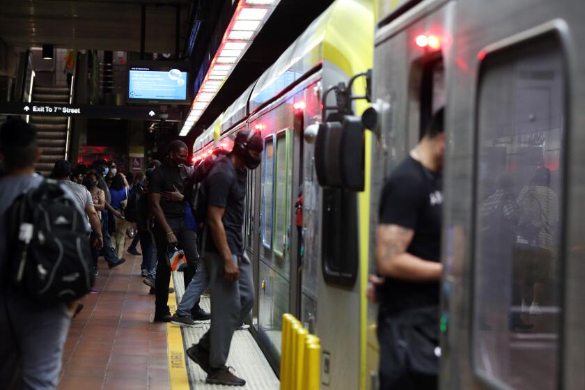 LOS ANGELES, CA - JULY 20: People enter the blue line at the 7th Street Metro Center on Monday, July 20, 2020 in Los Angeles, CA. Officials reported 2,848 newly confirmed COVID-19 cases on Sunday as hospitalizations have reached a new high. (Dania Maxwell / Los Angeles Times)