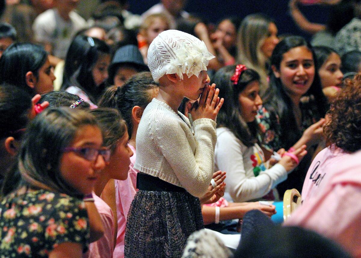 Fifth grader Grace Kesablak brings her hands to her face at the Homenetmen Ararat Chapter in Los Angeles at a benefit concert in her honor on Monday, March 24, 2014. Grace, a Chamlian Armenian School student, underwent her last treatment for cancer recently, and the benefit concert, hosted by TV host Diana Madison, included a magic act by John Gabriel, a song and dance performance by Luara Melody, and Sebu Simonian of Capital Cities who sang "Safe and Sound."