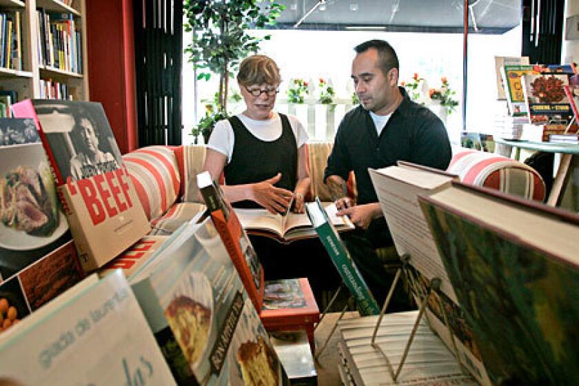 CLOSING: Cook's Library owner Ellen Rose looks over a book with staffer Alan Zumel.