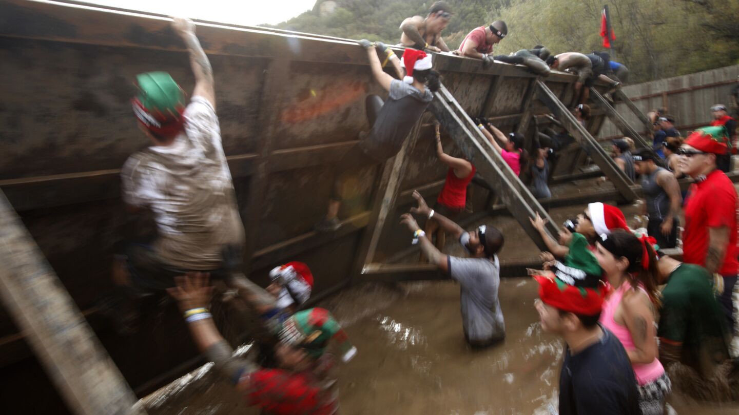 Participants receive a little help while trying to scale the"inverted wall" obstacle during the Spartan Race at Calamigos Ranch in Malibu on Dec. 7, 2014.