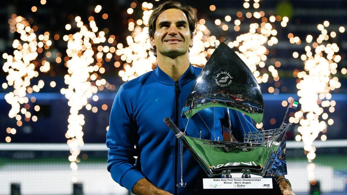 Roger Federer of Switzerland poses with the winner's trophy after defeating Stefanos Tsitsipas Dubai Championships on Satuday.