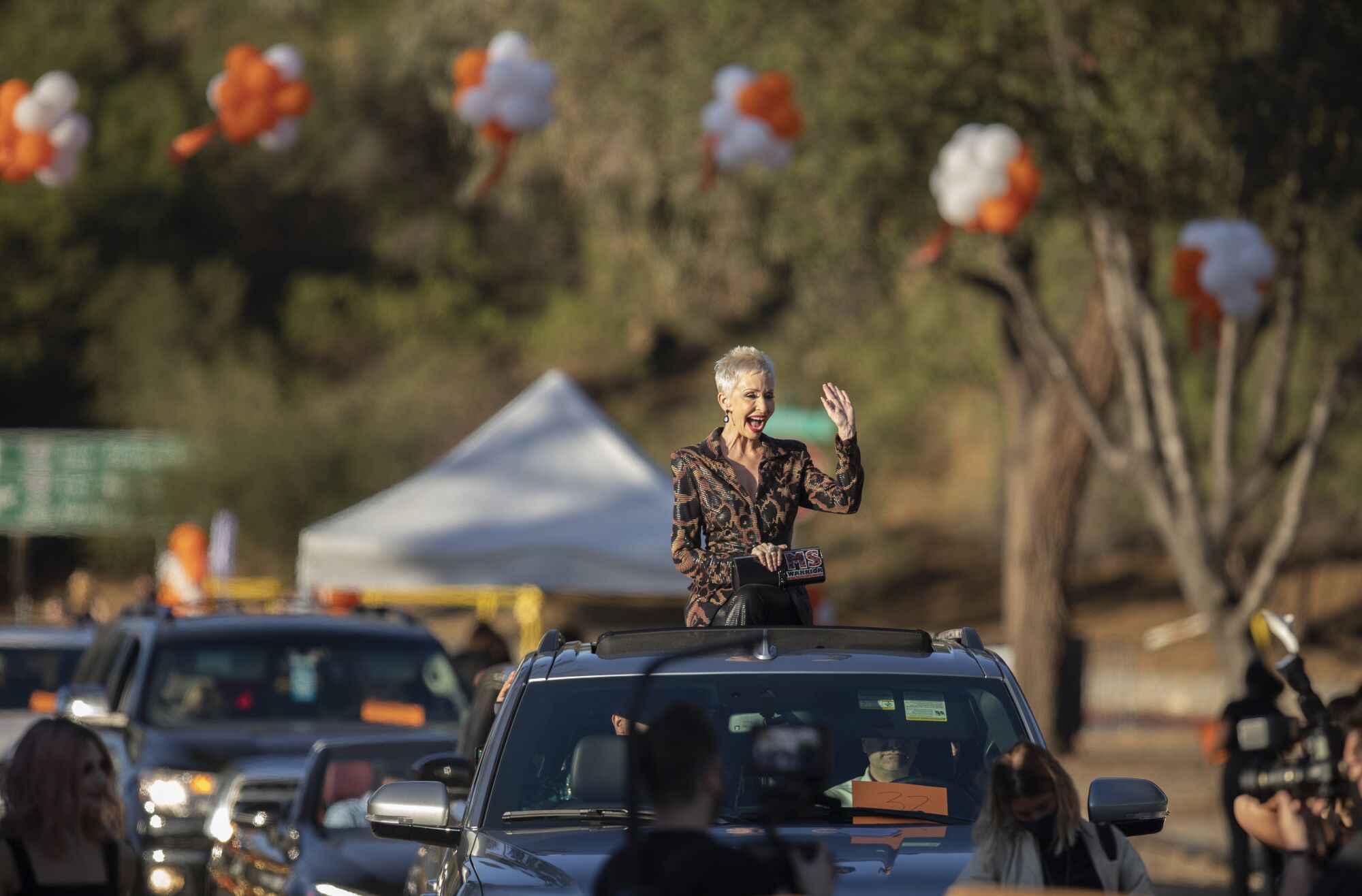 Actress Camerone Parker waves from the sunroof of a car during the arrival for the Race to Erase MS benefit at the Rose Bowl.