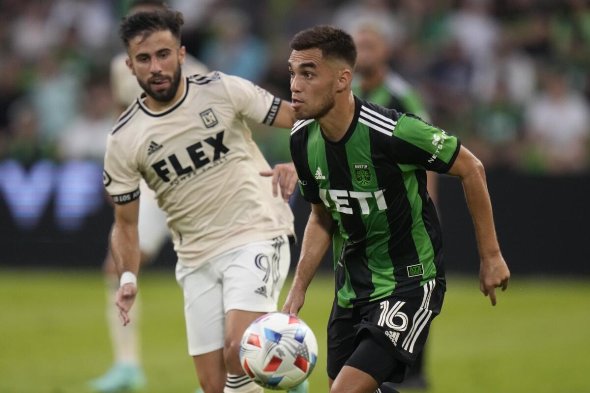 Austin FC midfielder Hector Jimenez does the ball past LAFC forward Diego Rossi.