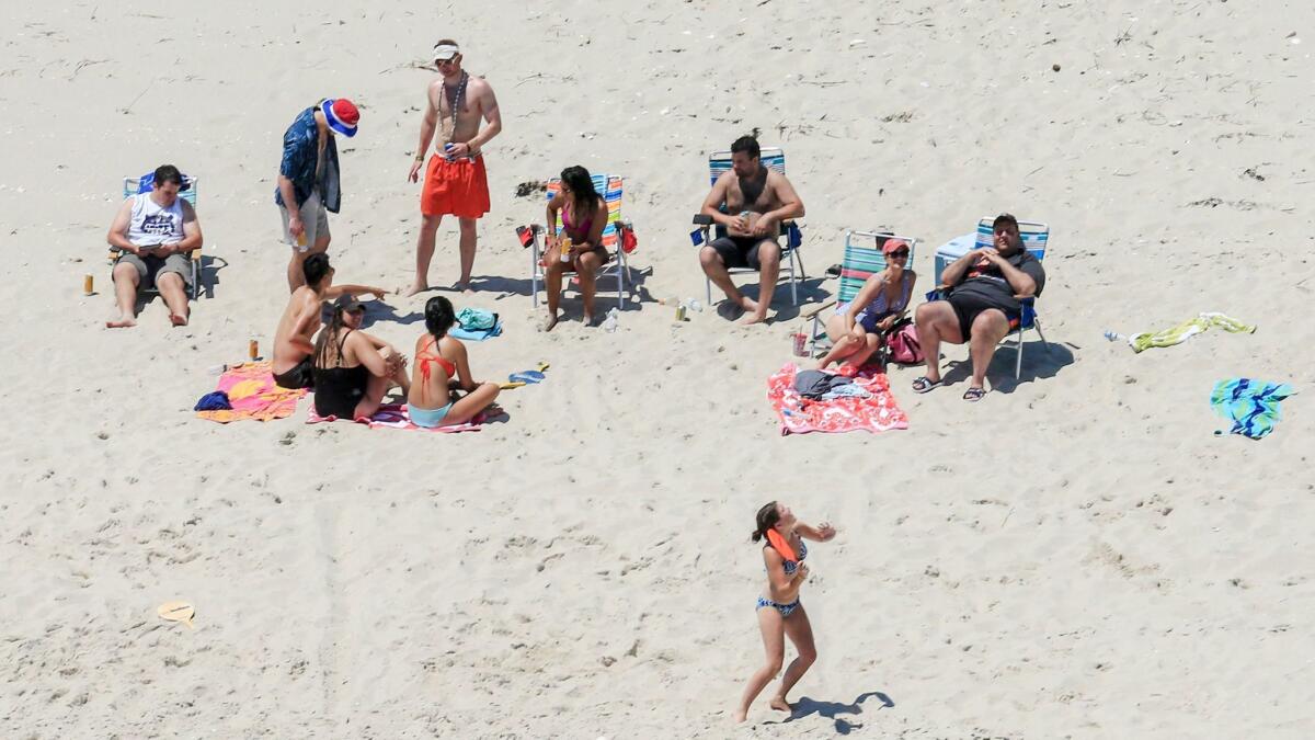 New Jersey Gov. Chris Christie, right, uses the beach with his family and friends at the governor's summer house at Island Beach State Park while the beach was closed to the public because of a government shutdown.
