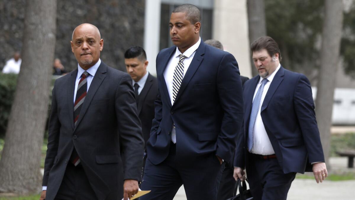 Jonathan Martin, center, walks with his attorney Winston McKesson, left, to be booked at the Los Angeles Police Department after pleading not guilty to making criminal threats at the Van Nuys Courthouse on Tuesday.