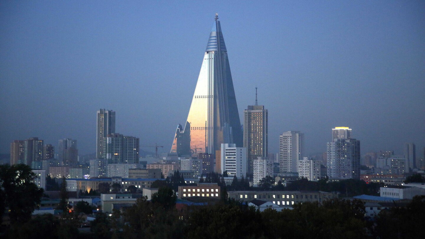 Dusk settles over Pyongyang, North Korea, as the 105-story pyramid-shaped Ryugyong Hotel towers over residential apartments. The landmark has been under construction since 1987 and was intended to be a symbol of progress and prosperity.