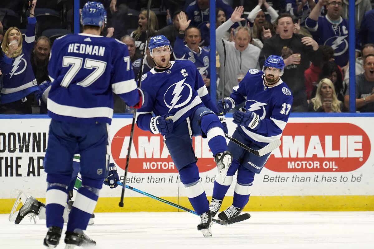 Tampa Bay Lightning center Steven Stamkos (91) celebrates his goal against the Vancouver Canucks with defenseman Victor Hedman (77) and left wing Alex Killorn (17) during the first period of an NHL hockey game Thursday, Jan. 13, 2022, in Tampa, Fla. (AP Photo/Chris O'Meara)