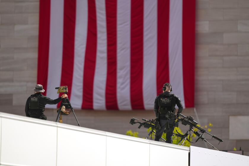 Members of the U.S. Secret Service police conduct overwatch during the IndyCar Freedom 250 Grand Prix auto race, Sunday, Aug. 23, 2026, in Washington. (AP Photo/Julia Demaree Nikhinson)