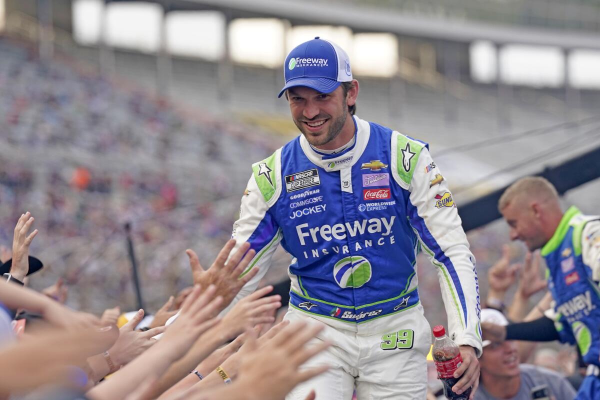 Daniel Suarez reaches to fans during driver introductions before the NASCAR All-Star auto race.