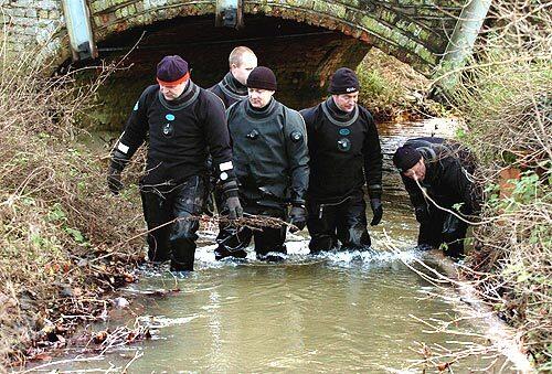 A British police dive search team looks upstream in Belstead brook, Hintlesham, where the bodies of murdered prostitute Gemma Adams and Tania Nicol were discovered.