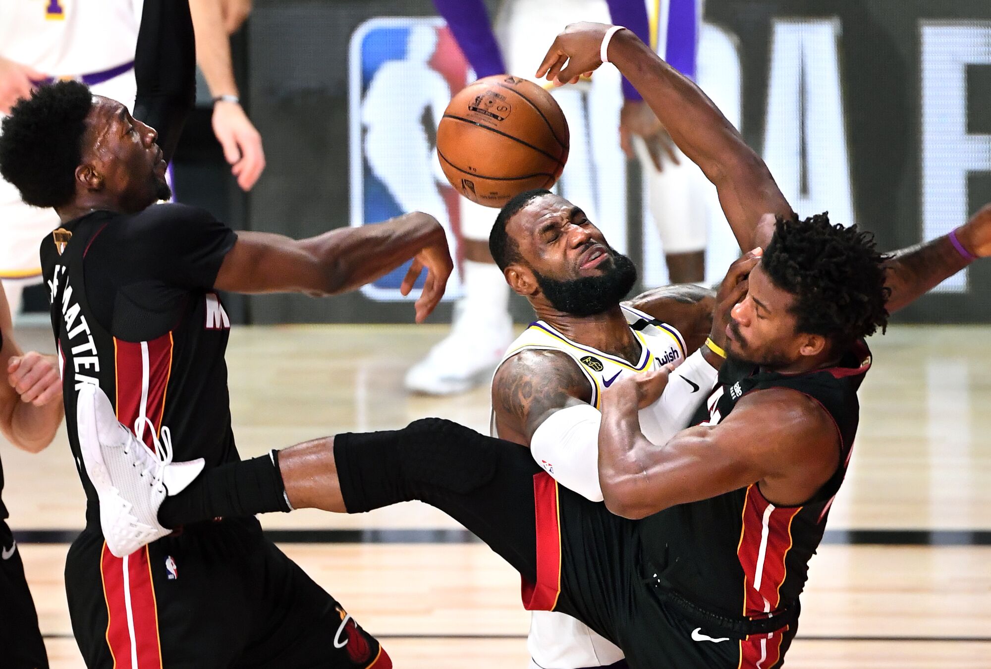 LeBron James is fouled by the Heat's Jimmy Butler, right, while driving to the basket
