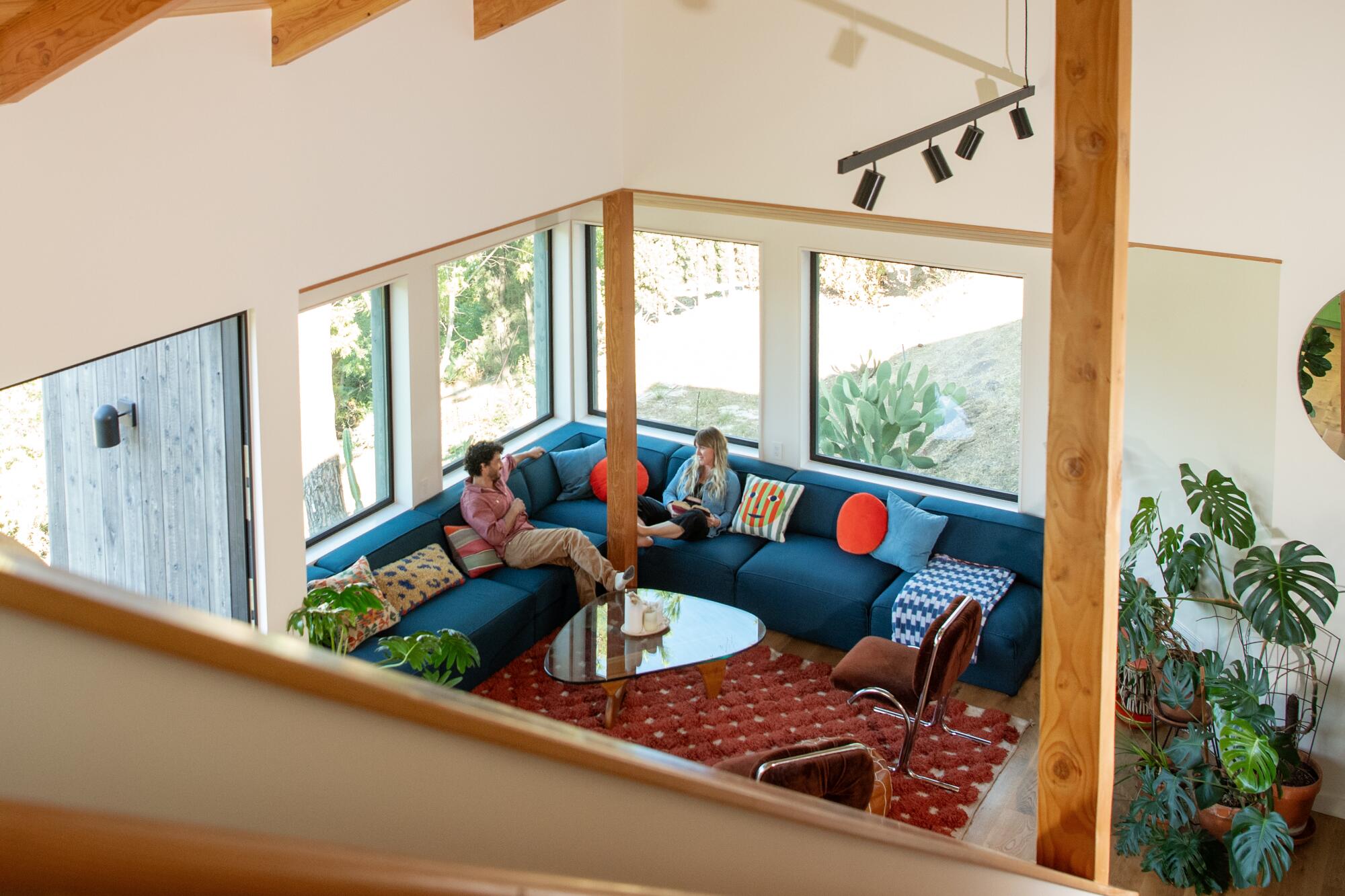 Daniel and Lindsay Sheron sit on the couch in their living room