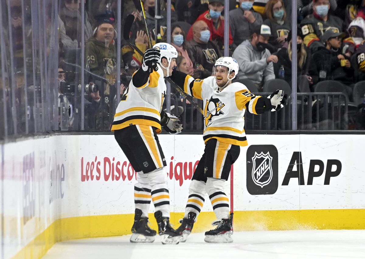 Pittsburgh Penguins center Teddy Blueger, right, celebrates his goal against the Vegas Golden Knights during the second period of an NHL hockey game Monday, Jan. 17, 2022, in Las Vegas. (AP Photo/David Becker)