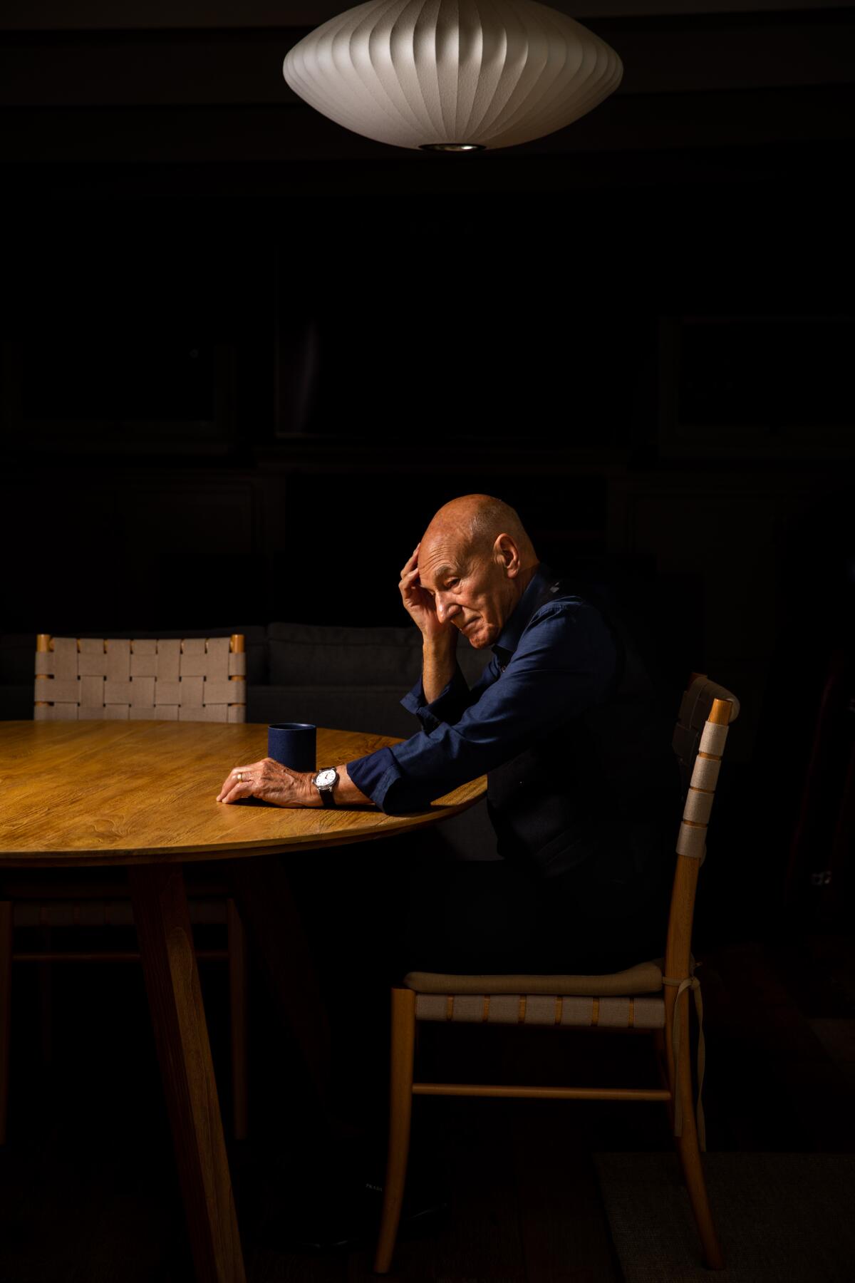 Patrick Stewart sits at a table at his Los Angeles home.