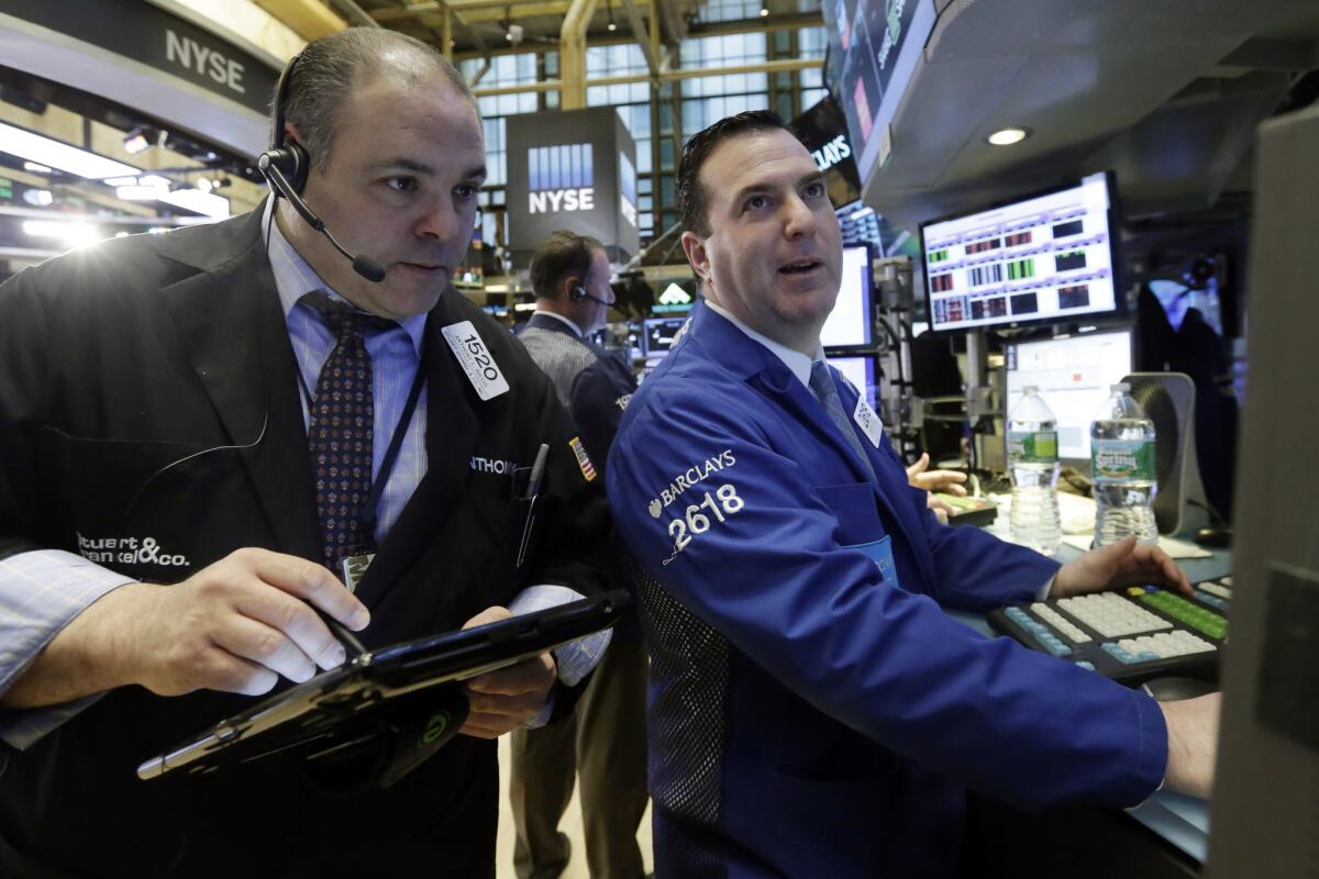 A trader, left, and specialist work on the floor of the New York Stock Exchange on Wednesday.