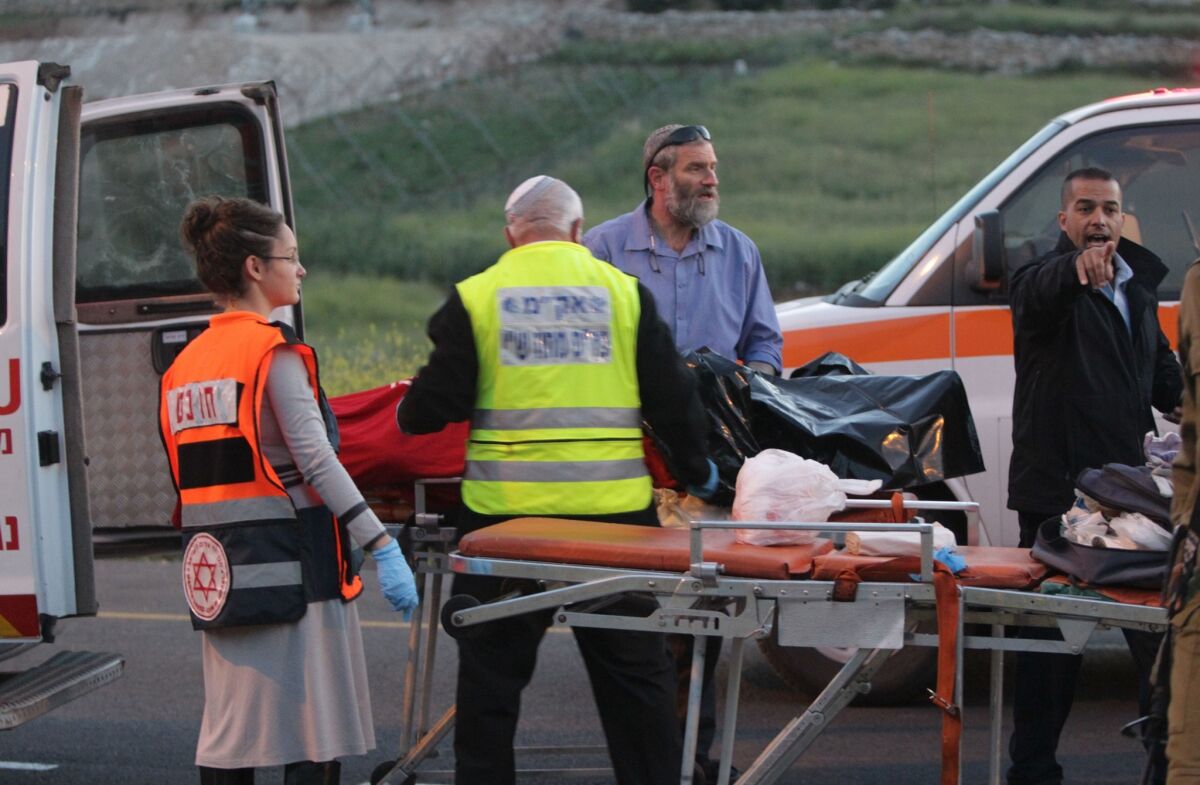 Israeli police and medical personnel load the body of an Israeli man into the back of an ambulance at the scene of a shooting near the southern West Bank city of Hebron.