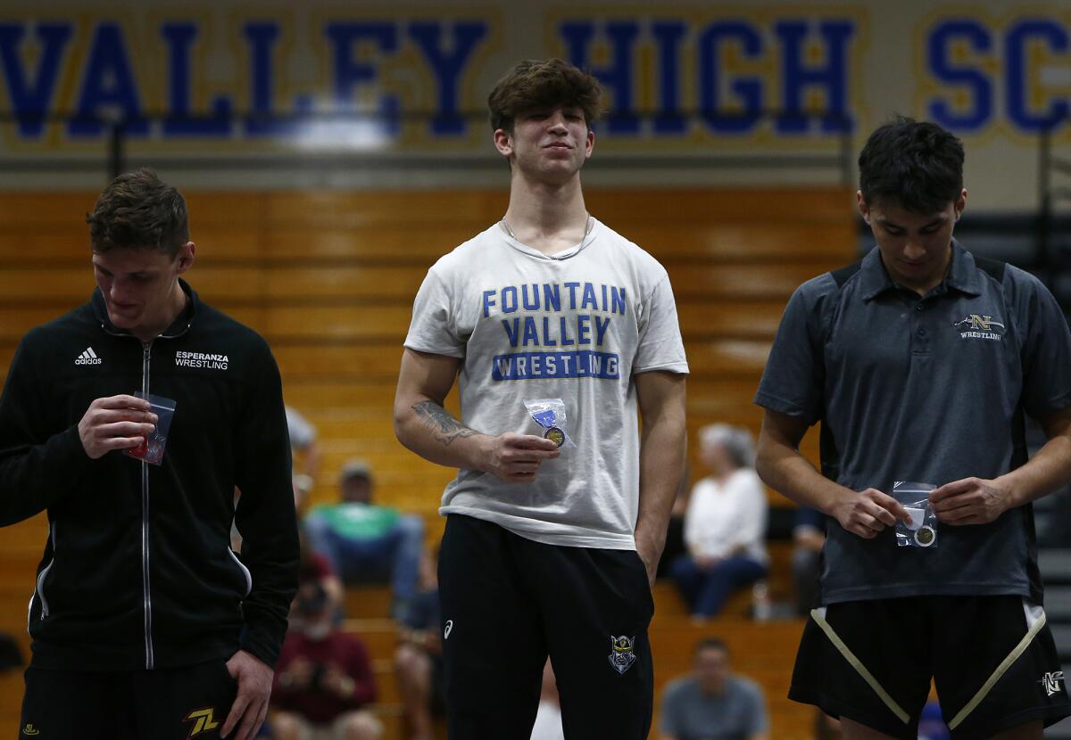 Fountain Valley's Zach Parker, center, holds his first-place medal as he stands on the podium among the 145-pound finalists.
