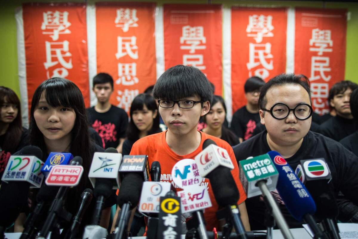 Student leader Joshua Wong, center, and other members of the group Scholarism hold a news conference regarding the group's future plans, in Hong Kong.