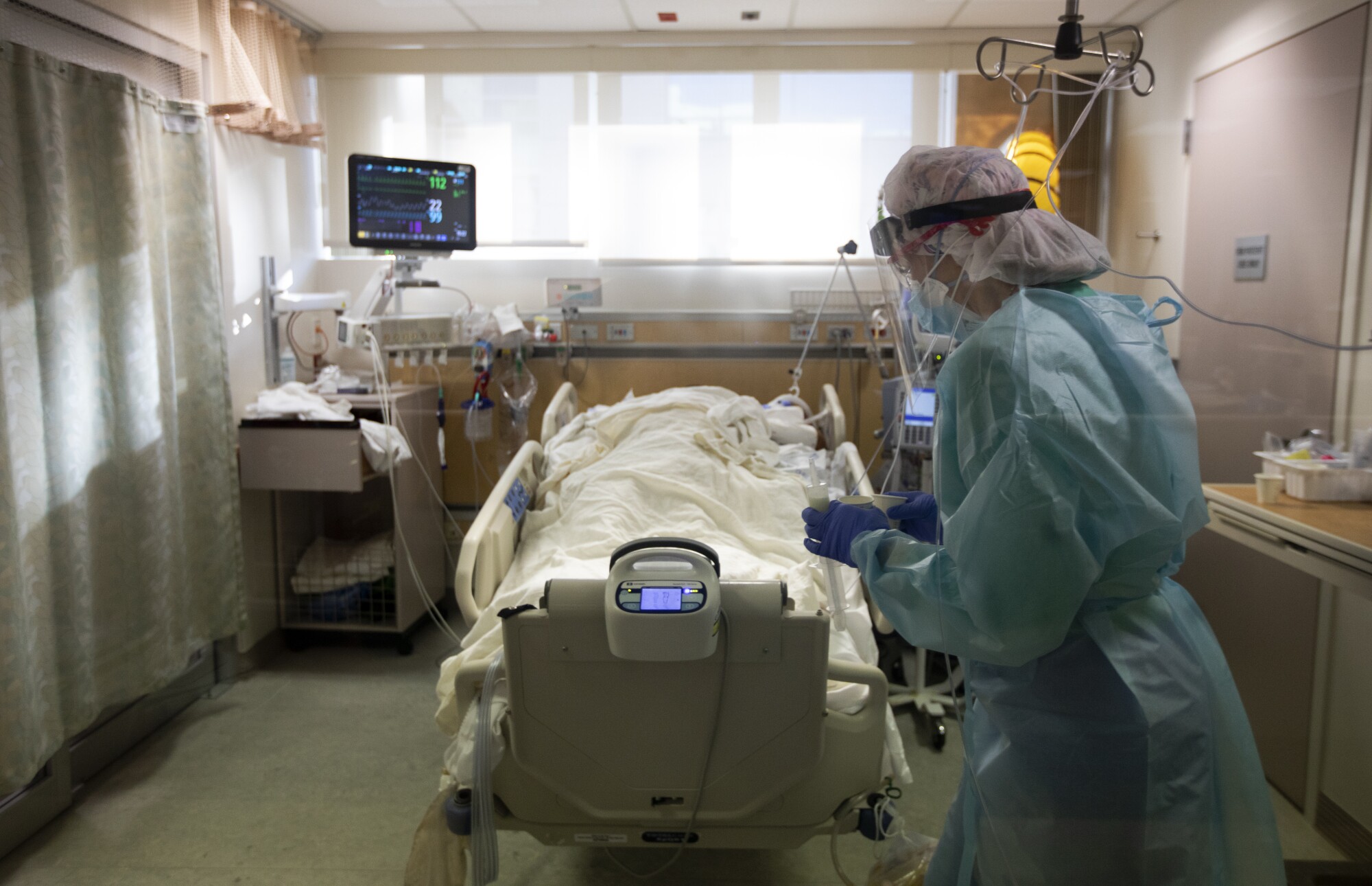 RN Joan Pung weaves her way through IV lines as she brings medication