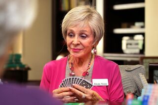Champion bridge player Rhoda Walsh plays bridge in a meeting room at the La Costa Glen retirement community.