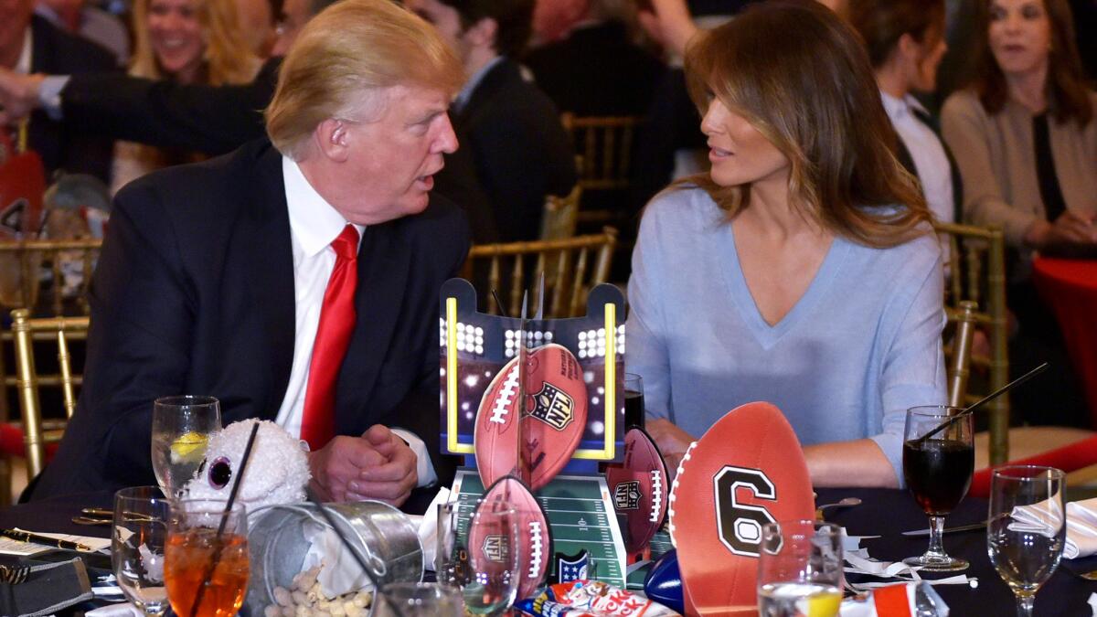 President Donald Trump chats with First Lady Melania Trump while watching the Super Bowl at Trump International Golf Club Palm Beach on Sunday.