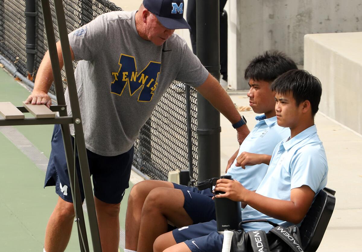 Marina boys' tennis head coach Chuck Kingman talks with Trevor Nguyen and David Tran during Thursday's match.