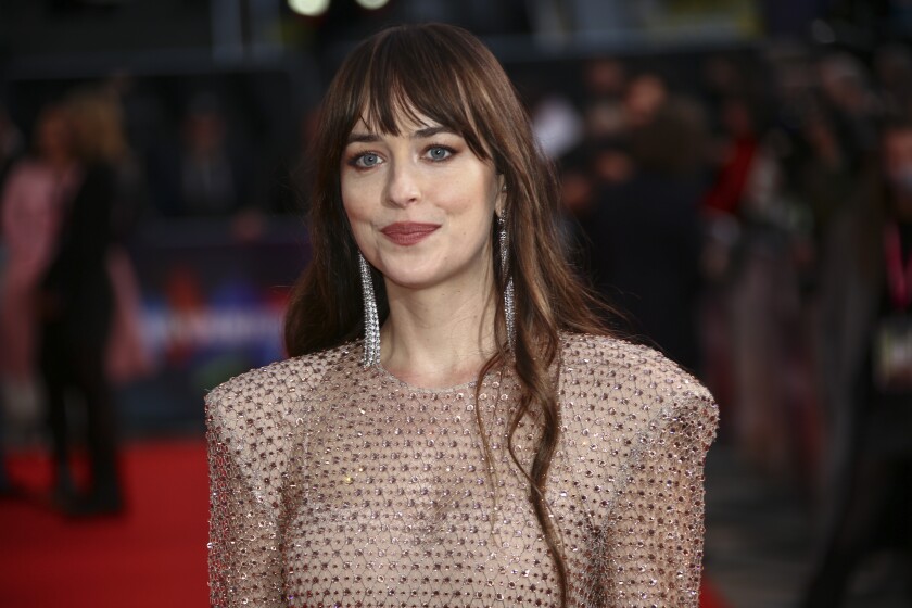 FILE - Dakota Johnson arrivews at the premiere of "The Lost Daughter" during the 2021 BFI London Film Festival in London, on Oct. 13, 2021. Johnson stars in “AM I OK?” and “Cha Cha Real Smooth,” which she also produced. (Photo by Joel C Ryan/Invision/AP, File)