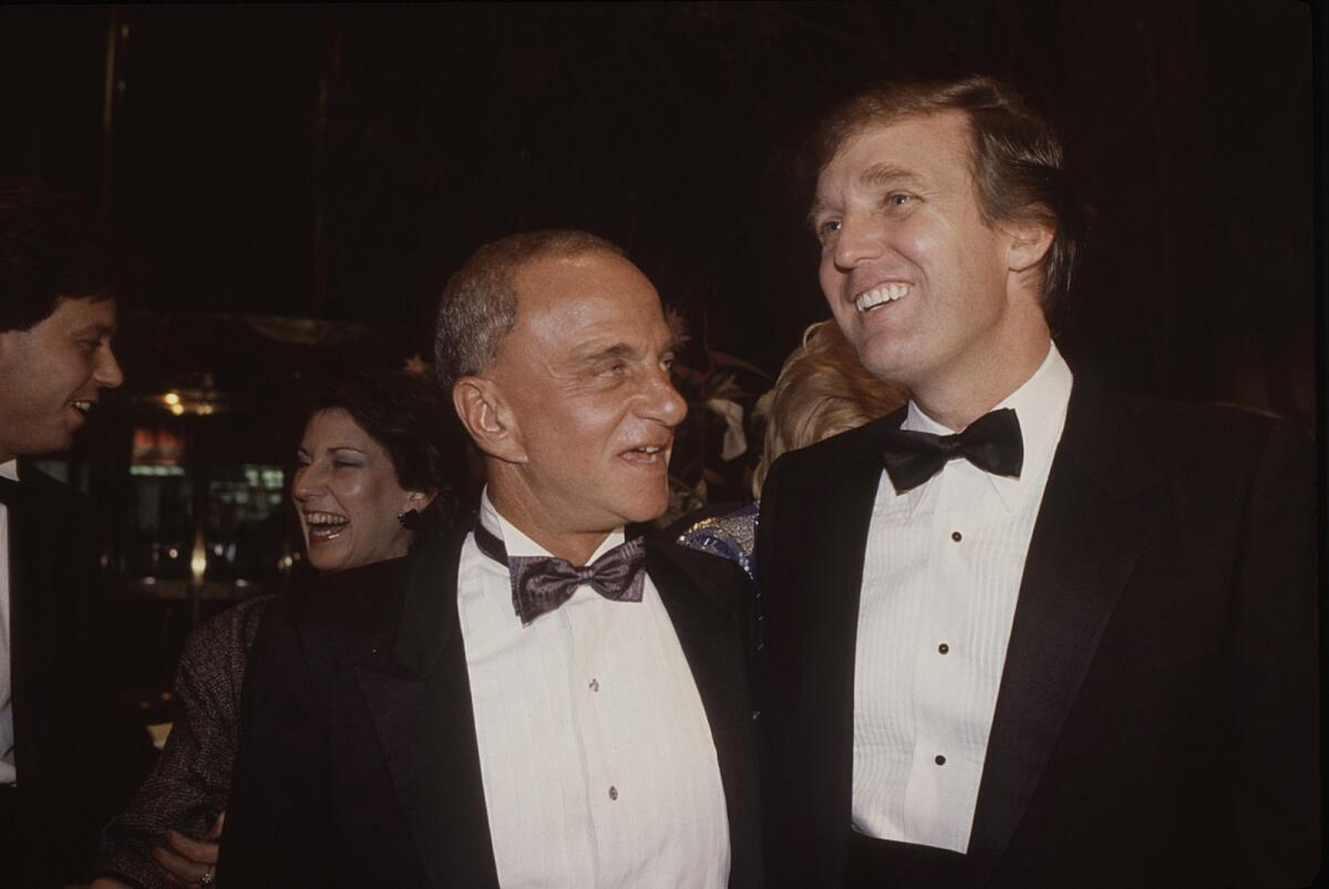 Roy Cohn and Donald Trump, both wearing tuxes, in 1983.