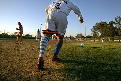 A fullback for team Azteca kicks to team Guerrro in a match at Centennial Park in Santa Ana. Soccer is taken very seriously in Santa Ana, where it is more an obsession than a sport.