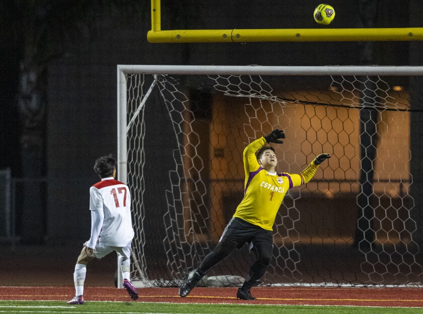 Santa Ana's Alejandro Garcia places a ball over the outstretched hands of Estancia's Cesar Pedroza for a goal on Friday.