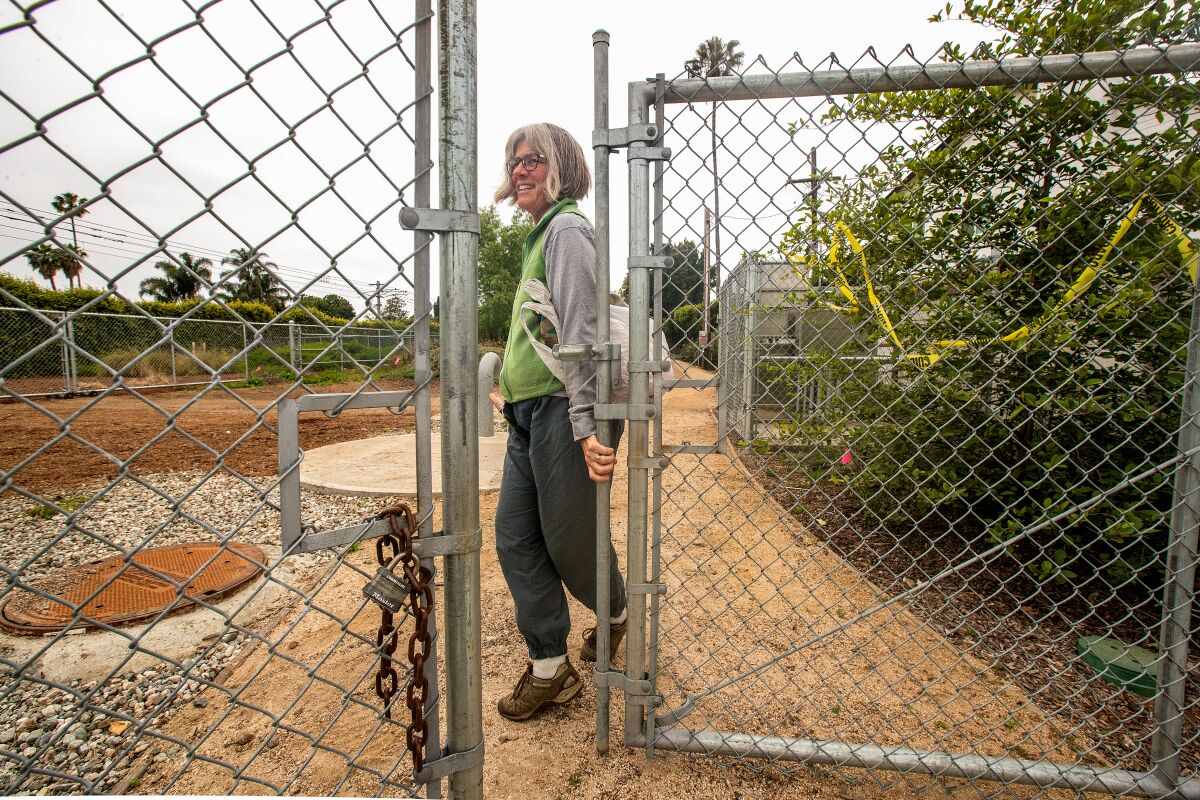 Annette Mercer opens the front gate to the Westwood Greenway.