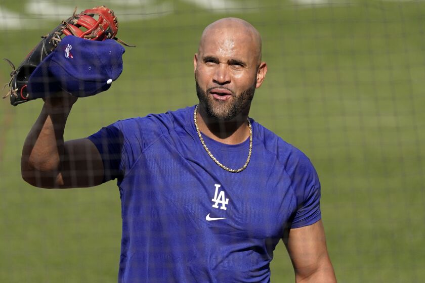 Los Angeles Dodgers first baseman Albert Pujols waves to people in the stands during batting practice.