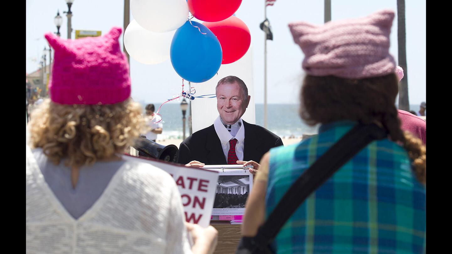 Demonstrators stand in front of a homemade life-size mock up of Congressman Dana Rohrabacher during “Heed Our Call” mock town hall meeting across the street from his offices in downtown Huntington Beach. The demonstration marked the 112th day since District 48 constituents have tried to get a meeting with the congressman.