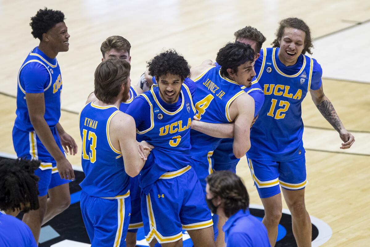 UCLA players celebrate after their 86-80 overtime win over Michigan State in a First Four game at the NCAA tournament.