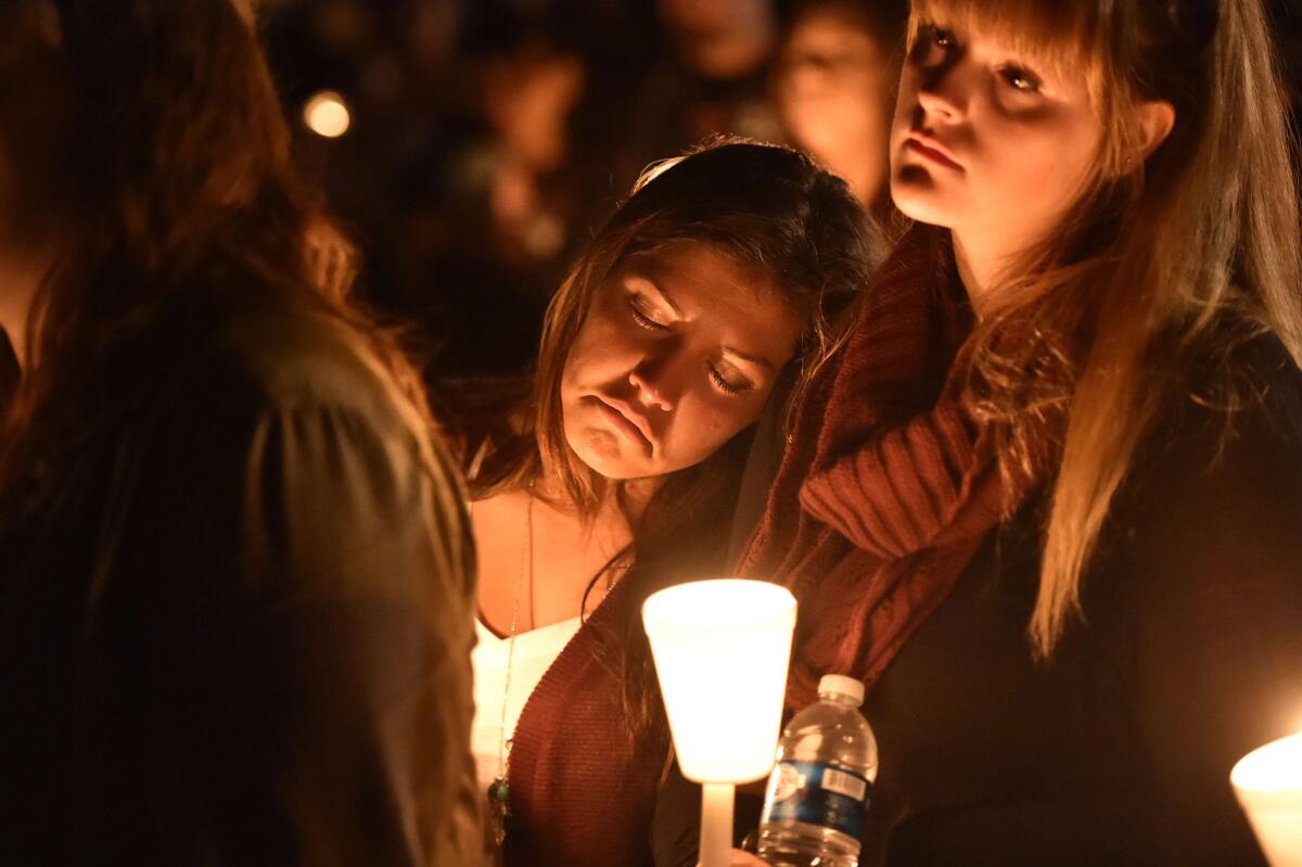 Kristin Sterner, center, a freshman at Umpqua Community College, mourns during an Oct. 1 vigil for shooting victims at the school in Roseburg, Ore.